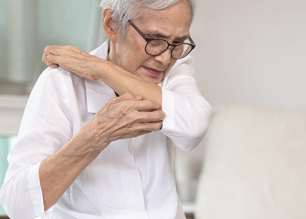elderly woman scratching shoulder.