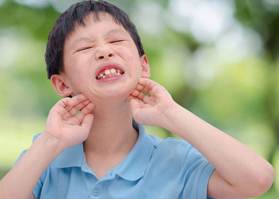 little boy scratching face.